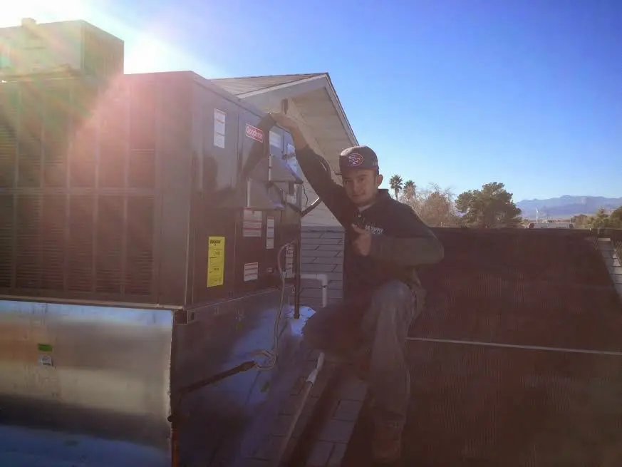 HVAC technician performing AC Tune-Up on a rooftop unit in Pleasant Hill